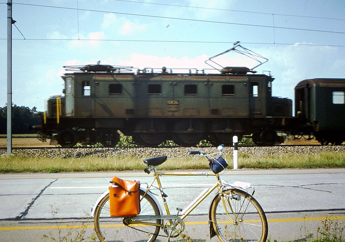 Ae 3/6 I 10634 im August 1979 irgendwo zwischen Stein am Rhein und Schaffhausen.
Als Jugendlicher war man damals noch stolz auf sein erstes Fahrrad 'mit Stange' und die erste mehrt�gige Radtour. Aus diesen Gr�nden wurde das Fahrrad bei der Tour um den Bodensee �fters mit ins Bild gestellt, wie leider auch bei diesem Bild. Aufnahme entstand mit einer Kleinbildsucherkamera Porst 135C mit sehr begrenzten Einstellm�glichkeiten (Entfernung 1, 1,5, 3 m oder unendlich sowie verschiedene ASA-Werte).