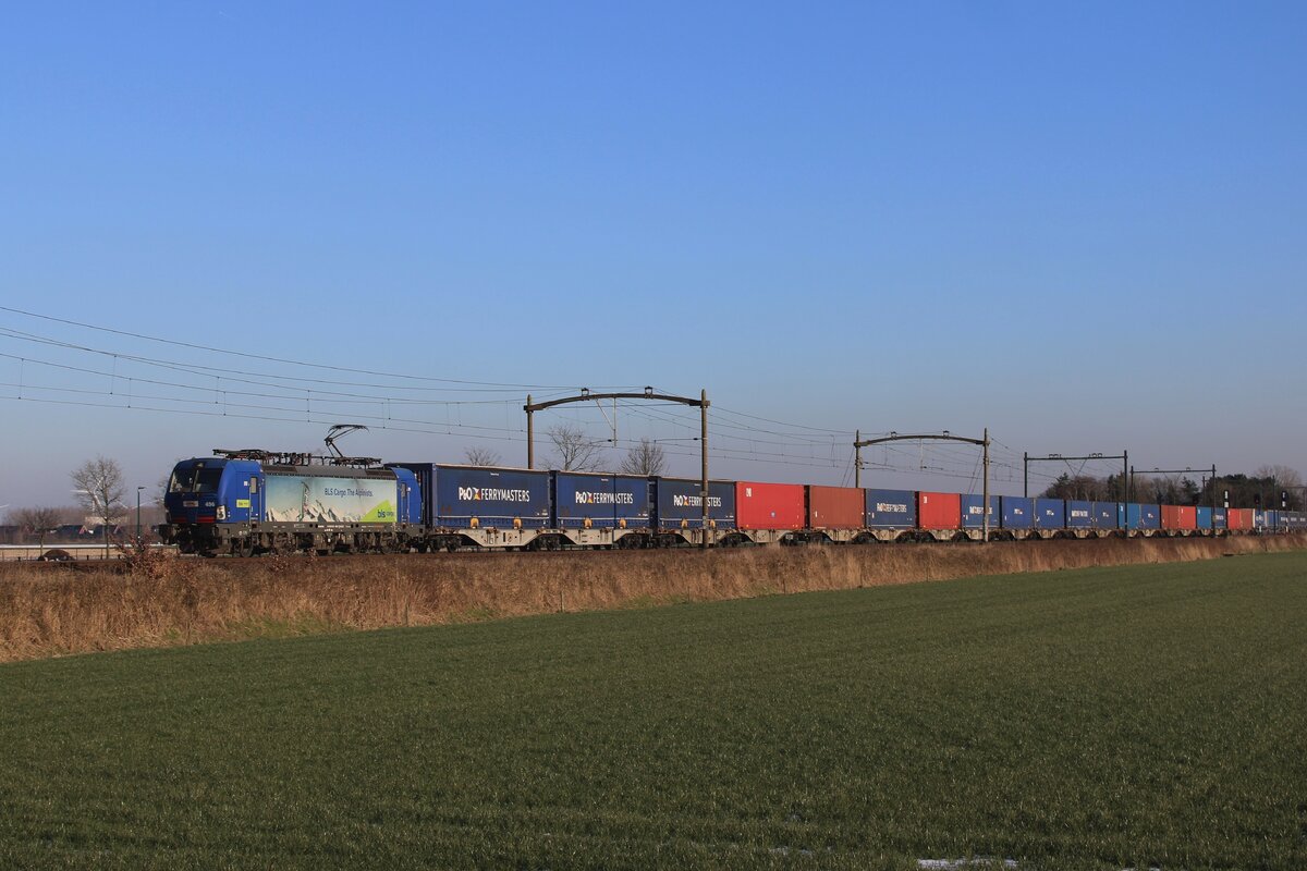 Am 19 Jänner 2024 zieht BLS Cargo 193 496 ein vollebladewner Containerzug durch Hulten.