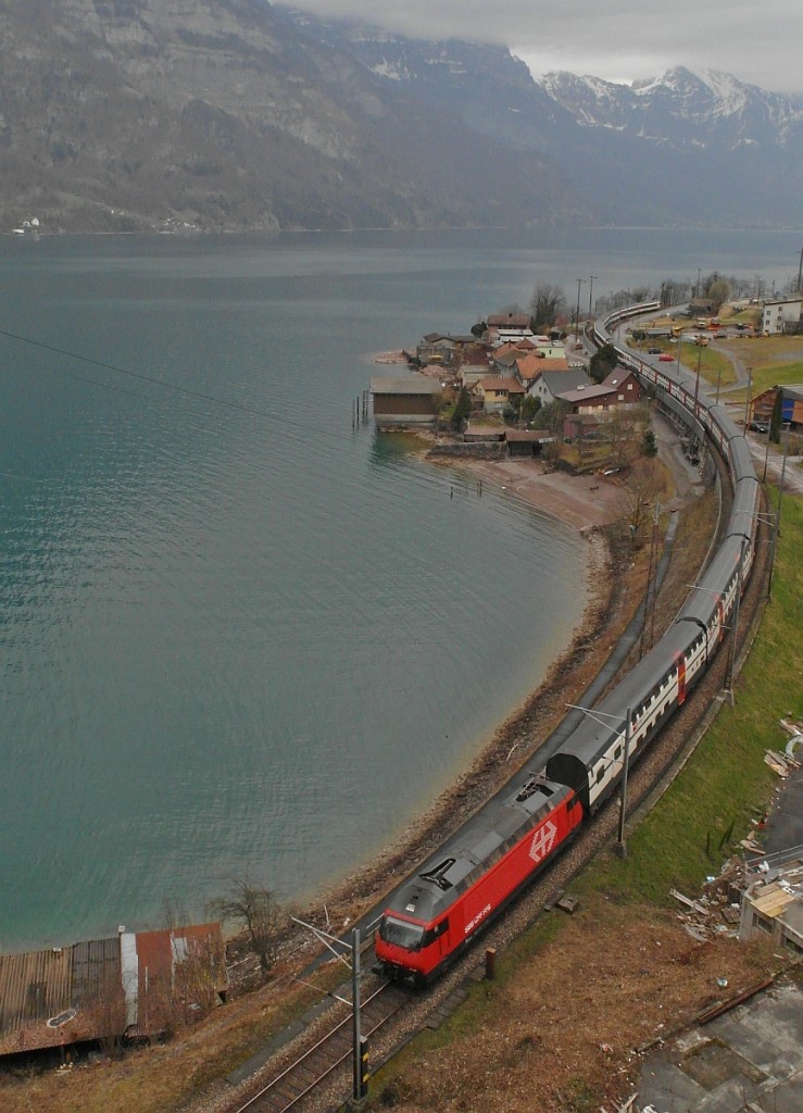 Den zwischen Tiefenwinkel und Mühlehorn einspurigen Streckenabschnitt entlang des Walensees befährt am 16.03.2014 die Re 460 mit ihrem 15 Wagen langen EC 206 auf der Fahrt von Chur nach Basel.