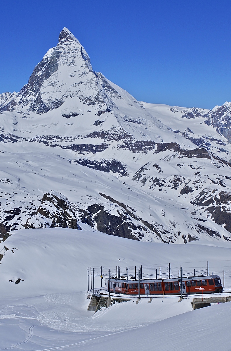 Der Bhe 4/6 3084 und ein unbekannter Bhe 4/6 als f�hrender Triebwagen haben am 10.05.2024 soeben die Bergstation der Gornergratbahn verlassen und fahren hinunter in das etwa 1400 tiefer gelegene Zermatt