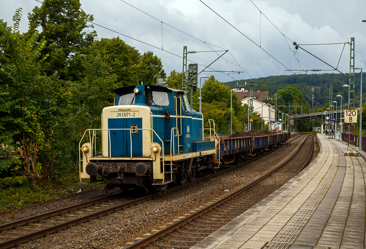 Die 261 671-2 (eigentlich laut NVR-Nummer 98 80 3361 671-1 D-AVOLL) der Aggerbahn (Andreas Voll e.K., Wiehl) fährt am 27.08.2021, mit einem Altschotter bzw. Aushub beladen Flachwagen-Zug (Niederbordwagen für Schotter und Sand der Gattung Klmos 702), durch den Bf Kirchen (Sieg) nach Betzdorf (Sieg).

Die V60 wurde 1959 von MaK unter der Fabriknummer 600260 als DB V 60 671 gebaut, 1968 erfolgte die Umzeichnung in DB 261 671-2, 1984 erfolgte schon die Ausmusterung bei der DB. Die Lok wurde nicht remotorisiert und hat so noch einen originalen gedrosselten Maybach 4-Takt-12-Zylindermotors mit 48 Liter Hubraum vom Typ GTO6A mit einer Leistung von 478 kW (650 PS) bei 1.400 U/min (ungedrosselt 588 kW bzw. 800 PS).

Die dieselhydraulische Lokomotive ist für den leichten und mittleren Rangierdienst sowie den Übergabezugdienst und bei Doppeltraktion auch für den schweren Rangierdienst vorgesehen. Sie hat ein hydraulisches Getriebe und Stangenantrieb. Bei der Konstruktion wurde Wert auf gute Zugänglichkeit und leichte Tauschbarkeit aller dem Verschleiß ausgesetzten Teile gelegt. Alle Großteile wie Motor, Getriebe, Kühlanlage, Luftpresser und elektrische Hilfsmaschinen können jeweils für sich allein ein- und ausgebaut werden.

In den 50er Jahren schlossen sich 8 Firmen in der Arbeitsgemeinschaft  Agm V 60  mit dem DB-Zentralamt München zusammen, es wurden insgesamt 942 Loks gebaut. Dabei gab es zwei unterschiedlich schweren Ausführungen: 623 Loks mit 48 t Dienstgewicht (BR 260/360) und als schwerere Variante 319 Loks mit verstärkten Rahmen- und Stirnwandblechen mit 54 t Dienstgewicht (BR 261/361), diese Lok ist eine der schweren Ausführung.

Bezeichnet wurden die Loks anfangs alle als V60, wobei nicht auf eine Unterscheidung zwischen leichter und schwerer Ausführung geachtet wurde. Mit Einführung des EDV-Nummernschemas bei der DB im Jahr 1968 wurden die leichten Loks als BR 260 eingereiht, die schwere Ausführung erhielt die BR 261.

Die V 60 ist eine Starrrahmenlok, Achsanordnung C, mit seitenverschieblicher Mittelachse, wobei die Achsen mittels Kuppelstangen von einer Blindwelle angetrieben werden.

Diese Lok hat einen gedrosselten Maybach 4-Takt-12-Zylindermotors mit 48 Liter Hubraum vom Typ GTO6A mit einer Leistung von 478 kW (650 PS) bei 1.400 U/min (ungedrosselt 588 kW bzw. 800 PS). Die Leistung des Dieselmotors wird über eine Schwingmetallkupplung und eine Gelenkwelle auf das hydrodynamische Voith-Getriebe L27zuB übertragen. Das Voith-Getriebe ist mit einem mechanischen Stufen- und Wendegetriebe zu einem Block zusammengeflanscht. Die Kraftübertragung erfolgt über eine zwischen dem 2. und 3. Radsatz liegenden Blindwelle, Blindwellenkurbeln an den beiden Blindwellenenden und Kuppelstangen auf die Räder der Lok.

Technische Daten:
Achsanordnung: C
Länge über Puffer: 10.450 mm
Gesamtachsabstand: 4.400 mm
Raddurchmesser: 1.250 mm (neu) / 1.180 mm (abgenutzt)
Höchstgeschwindigkeit im Streckengang: 60 km/h
Höchstgeschwindigkeit im Rangiergang: 30 km/h
Nennleistung: gedrosselt auf 478 kW (650 PS) bei 1.400 U/min 
Anfahrzugkraft: 117,6 kN
Gewicht: 53,0 t
Kraftübertragung: hydraulisch
Antriebsart: Blindwelle-Stangen
Kleinster befahrbarer Krümmungsradius: 100m

Übersicht der Baureihen-Bezeichnung (V60):
BR V 60 ursprüngliche Bezeichnung ab Ablieferung bis 1.1.68

BR 260 leichte Ausführung bis Okt. 1987
BR 261 schwere Ausführung bis Okt. 1987

BR 360 leichte Ausführung
BR 361 schwere Ausführung

BR 362 modernisierte leichte Ausführung mit Funk und neuen CAT 3412E DI-TTA Motor
BR 363 modernisierte schwere Ausführung mit Funk und neuen CAT 3412E DI-TTA Motor

BR 364 leichte Ausführung mit Funkfernsteuerung
BR 365 schwere Ausführung mit Funkfernsteuerung
