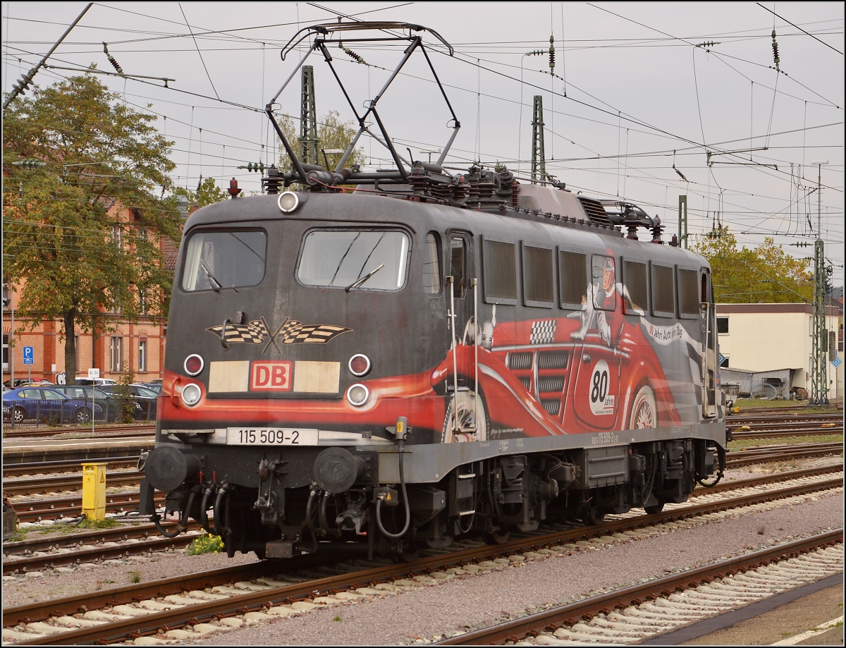 Die exotische 115 509-2 mit der Autozugwerbung in Diensten der Gäubahn-ICs wartet in Singen auf den nächsten Einsatz. Oktober 2015.