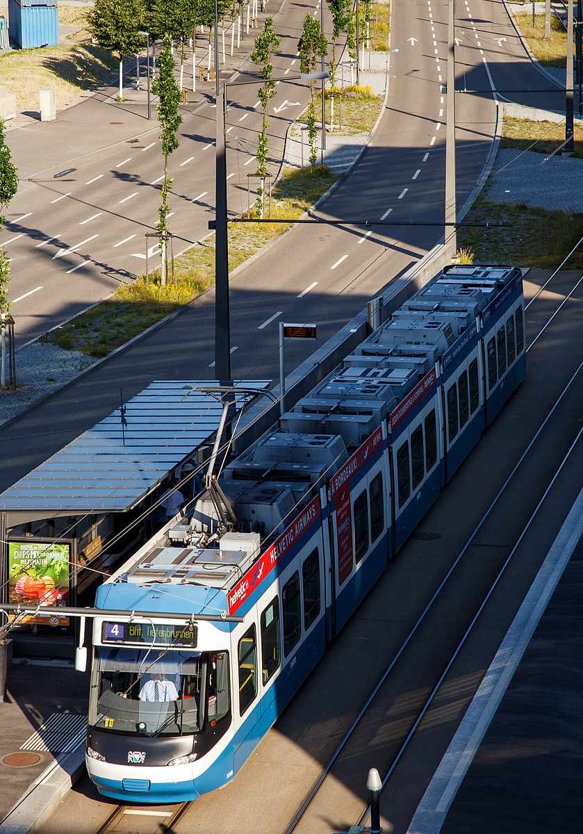 Die VBZ-Tram - Be 5/6 3028, eine Bombardier Cobra, als Linie 4 zum Bf. Tiefenbrunnen am 07.06.2015 beim Halt an der Station Technopark (Z�rich). Blick von unserem Hotel.

Auch wenn das Cobra-Tram nur in Z�rich f�hrt, handelt es sich mit 88 Fahrzeugen um eine beachtlich gro�e Flotte, die St�ckzahlm�ssig von einigen Konkurrenzangeboten nie erreicht wurde.

Die Idee und Entwicklung zum heutigen Cobra-Tram geht bis ans Ende der Achtzigerjahre zur�ck. Das Rollmaterial-Konsortium „Z�ri-Tram“ begann mit der Entwicklung eines eigenen niederflurigen Trams. Hinter diesem Konsortium standen die langj�hrigen Z�rcher Hauslieferanten Schindler Waggon (SWP; Wagenkasten, mechanische Teile), Schweizerische Industrie-Gesellschaft (SIG; Fahrwerk) und BBC respektive Asea Brown Boveri (ABB; Traktionsausr�stung, elektrische Teile). Im Vordergrund standen bei der Entwicklung die Normalien der Z�rcher und Basler Tramnetze, wo man die Kunden f�r das Fahrzeug ortete. Dennoch war es Juni 2001, als das erste fertige Fahrzeug der �ffentlichkeit pr�sentiert wurde. 

Ein langes Verfahren bei der Beschaffung der Fahrzeuge, technische Schwierigkeiten und die grundlegenden Ver�nderungen bei der schweizerischen Rollmaterialindustrie f�hrten zu dieser Verz�gerung. Durch �bernahmen bestand das Konsortium letztendlich aus Bombardier Transportation Schweiz (Federf�hrung), Alstom und Alusuisse Road & Rail. Urspr�nglich waren die Fahrzeuge beim Hauptlieferanten Schindler Waggon Pratteln (SWP) bestellt worden. Die Schindler Holding verkaufte 1997 ihre Rollmaterial-Tochtergesellschaft Schindler Waggon an Adtranz, die wiederum 2000/2001 von Bombardier Transportation �bernommen wurde. Die SIG Holding, die ihre Schienenfahrzeugsparte bereits in einem Joint-Venture mit dem Fiat-Konzern zusammengelegt hatte, verkaufte sp�ter ihre Anteile an der Fiat SIG Schienenfahrzeuge AG, die schlie�lich mit der kompletten Fiat-Schienenfahrzeugsparte von Alstom �bernommen wurde.

Heutzutage geh�rt  die Cobra   bzw. Gelenkmotorwagen Be 5/6 zu Z�rich wie das Matterhorn zu Zermatt.

Das Tram vom Typ Cobra wurde eigens f�r die spezifischen Voraussetzungen der Stadt Z�rich entwickelt. Zu ber�cksichtigen waren u.a. starke Steigungen (bis zu 77 Promille bei jeglicher Witterung), enge Kurven (R 14 m), st�dtebauliche Vorgaben bei Trassees und Haltestellen, die gro�e Passagierzahl (0.5 Mio. Personen pro Tag) sowie kurze Fahrgastwechselzeiten. Das Cobra-Tram sch�pft mit seiner optimalen L�nge und Breite sowie mit seinen sieben breiten T�ren die Platzverh�ltnisse maximal aus. Die Einzelradfahrwerke mit Radialsteuerung und seitenselektivem Antrieb verhindern l�stiges Kurvenquietschen. Die durchgehende 100%-Niederflur-Konstruktion erm�glicht ein bequemes Ein- und Aussteigen, insbesondere f�r �ltere Menschen, Personen mit Rollst�hlen und Kinderwagen. Ein modernes Innen- und Au�endesign sowie eine Klimaanlage in den Seriefahrzeugen runden das Profil dieses neuen Flaggschiffes der VBZ bzw. VBG ab. 

Die Fahrzeuggeometrie passt  sehr gut zum Anforderungsprofil, insbesondere konnten hinter dem F�hrerstand und am Fahrzeugende normal breite Einstiege konzipiert werden. W�ren wie beim Tram 2000 nur vier der sechs Achsen angetrieben, k�nnte die Forderung nicht erf�llt werden, dass bei Ausfall eines Drehgestells noch mind. 40% Adh�sionsgewicht bleiben muss. Da beim Cobra die Fahrmotoren l�ngs angeordnet sind und jeweils zwei R�der hintereinander antreiben, musste tief in die Trickkiste gegriffen werden: Das mittlere Fahrwerk ist nur links angetrieben, so dass es rechts zwei unangetriebene Losr�der hat, zwischen welchen eine der sieben T�ren angeordnet ist. Damit d�rfte es sich beim Cobra um das allererste asymmetrisch angetriebene Schienenfahrzeug weltweit handeln (an der linken Seite sind alle sechs R�der angetrieben und an der rechten Seite / Einstiegsseite lediglich 4).

Die Gelenktreibwagen sind f�nfteilig, die Endeinheiten und das Mittelteil ruhen auf den Drehgestellen, die Zwischenteile sind als S�nften ausgef�hrt. Die Triebwagen sind Einrichtungfahrzeuge (f�r eine Fahrtrichtung)  und besitzen nur an der rechten Seite Einstiegst�ren.

Technische Daten:
Typ: Einrichtungs -Gelenkmotorwagen Be 5/6  „Cobra“
Spurweite: 1.000 mm
Anzahl der Fahrzeuge: 8 in vier Serien (Von 2000 bis 2010)
Gesamtl�nge:  36 m
Achsabst�nde: 3.250 / 9.100 / 3.250 / 9.100 / 3.250 mm
Breite:  2.400 mm
H�he: 3.600 mm
Gewicht : 39.2 Tonnen
Sitzpl�tze:  96
Stehpl�tze: 142 (bei 4 Personen pro m2
Geschwindigkeit max.:  70 km/h
Anzahl T�ren:  7 (je 1.300 mm breit)
Radpaare:  6 in 3 Fahrwerken
Raddurchmesser neu:  560 mm
Raddurchmesser abgenutzt:  500 mm
Anzahl Motoren:  5
Motorenleistung:  5�125 kW = 625 kW
Stromsystem: 600 V DC
Anzahl Stromabnehmer:  1
Einstiegsh�he bei leerem Fahrzeug:  35 cm
IGBT Wechselrichter mit Rekuperationsm�glichkeit  erm�glicht Energier�ckgewinnung beim Bremsen und damit h�heren Wirkungsgrad
Betreiber:  Verkehrsbetriebe Z�rich (VBZ) und Verkehrsbetriebe Glattal (VBG) 