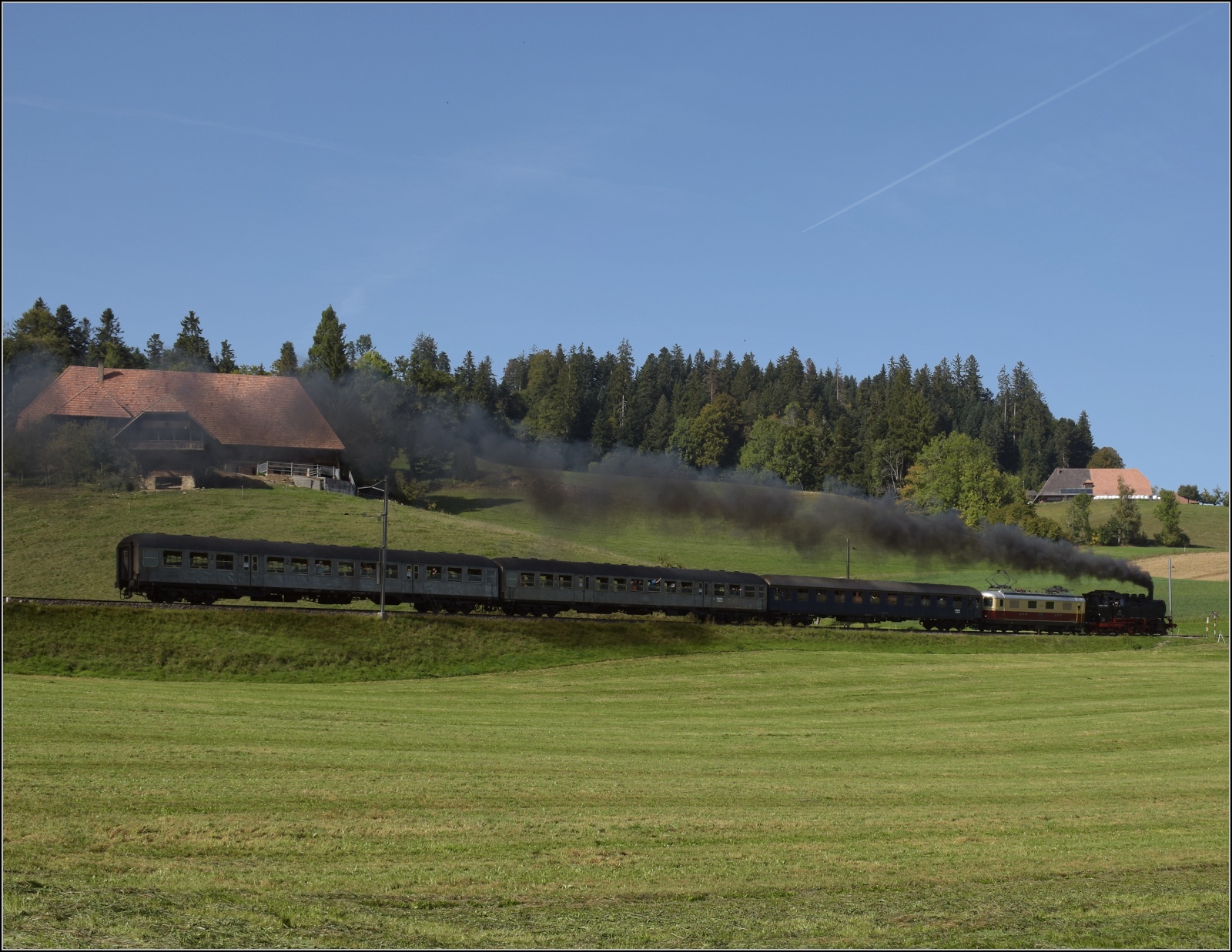 Dampftage Huttwil mit frisch genesenem Bubikopf. 

Bei Oberbaumen geht es f�r 64 518 und Re 4/4 I 10034 die steile Rampe nach Weier hinauf. Die Fotowolke war eigenproduziert... Oktober 2023.