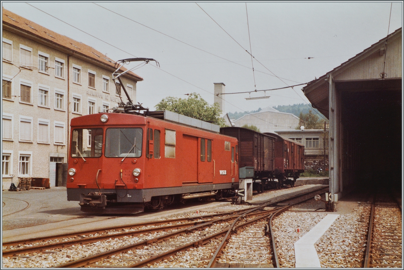 Der WSB De 4/4 steht mit einem aufgebockten Gklm und einem Gs als Güterzug 550 in Menziken Burg und wartet auf die Abfahrt nach Suhr.

15. Mai 1984