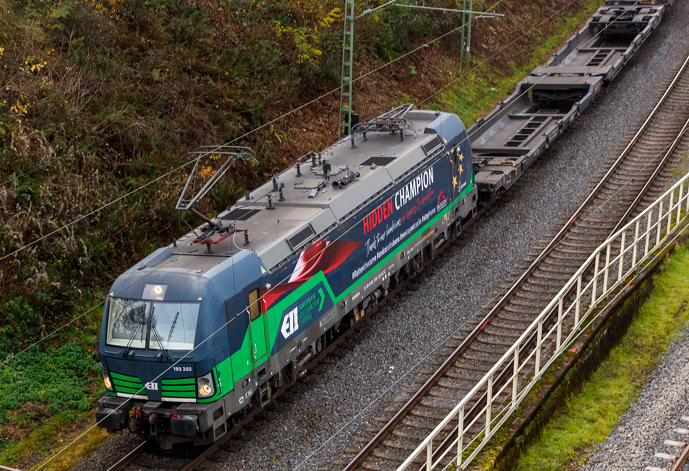 Die noch an die TXL - TX Logistik AG (Troisdorf) vermietete Siemens Vectron AC 193 203 (91 80 6193 203-7 D-ELOC) „HIDDEN CHAMPION“ (englisch für heimliche Gewinner oder unbekannte Weltmarktführer) der ELL Austria GmbH (European Locomotive Leasing, Wien), fährt am 13 November 2025 mit einem leeren Taschenwagenzug durch Betzdorf/Sieg in Richtung Siegen. Der Mieter TXL setzt nun auf eigene Vectron Loks, es wurden 40 modernen Vectron-Lokomotiven bei Siemens Mobility bestellt.

Die Siemens Vectron AC wurde 2014 von Siemens Mobility GmbH in München-Allach unter der Fabriknummer 21923 gebaut und an die der European Locomotive Leasing (Wien) geliefert. Diese Vectron Lokomotive ist als AC – Lokomotive (Wechselstrom Lok) in der Variante B01 mit 6.400 kW konzipiert und zugelassen für Deutschland und Österreich. So besitzt sie die Zugsicherungssysteme ETCS BaseLine 3, sowie für Deutschland PZB90 / LZB80 (CIR-ELKE I) und für Österreich (ETCS Level 1 mit Euroloop, ETCS Level 2, PZB90 / LZB80. 