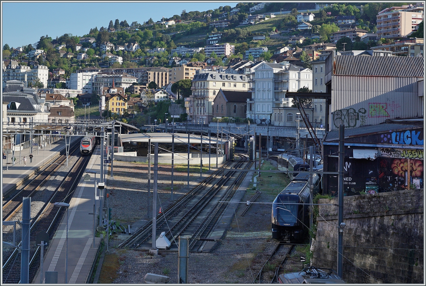 Ein Blick auf den Bahnhof von Montreux von Südosten her. Rechts die relativ ausgedehnte Gleisangelange der MOB, Links die abgespeckte SBB Gleisanlage mit lediglich zwei Gleisen.  Im Hintergrund erreicht ein FS Trenitalia ETR 610 als EC 143 nach Domodossola Montreux, rechts im Bild ist ein abgestellter GPX zu sehen.   

29. April 2025