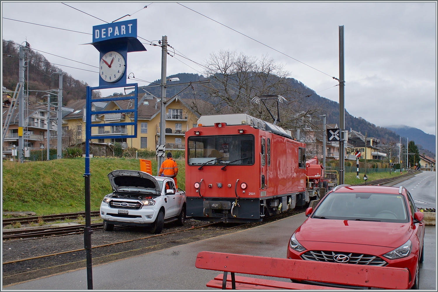 HGem 2/2 2501 nennt sich die Lok im Vordergrund; und das Auto mitten auf den Schienen im Bahnhof von Blonay kümmert sich um das  m  in der Lokbezeichnung: Die Lok wird betankt!

1. März 2024