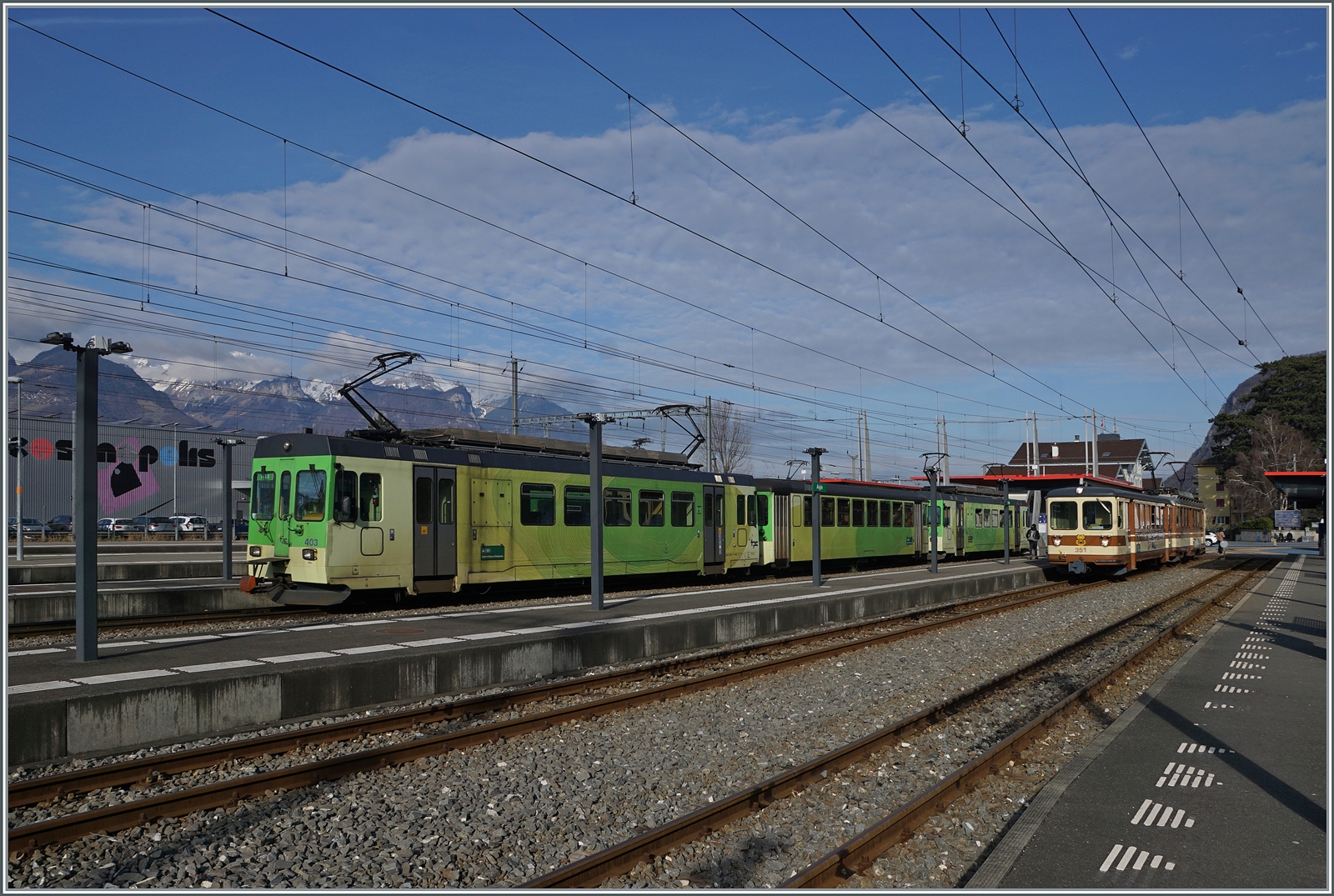 In Aigle wartet der TPC ASD BDe 4/4 403 mit Bt (ex BLT) und einem weitern BDe 4/4 auf die nächste Fahrt nach Les Diablerets, während im Hintergrund der letzte noch in A-L Farben gehaltene Pendelzug steht. 

17. Feb. 2024