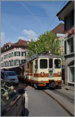 Der A-L Regionalzug 235 auf der Fahrt nach Leysin bei der hindernisreichen Fahrt durch die Altstadt von Aigle.